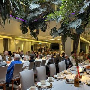 Wigilia w Eurohotelu dla osób starszych, samotnych oraz uczestników placówek wsparcia dziennego. Widać trzy rzędy stołów przy których siedzą goście.