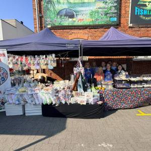 Zdjęcie przedstawia targowisko miejskie w Swarzędzu. Pod niebieskimi namiotami widać dwa stoiska Koła Gospodyń Wiejskich z Jasina.