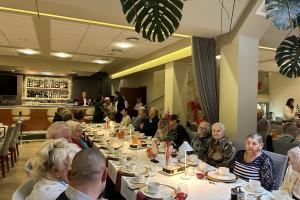 Wigilia w Eurohotelu dla osób starszych, samotnych oraz uczestników placówek wsparcia dziennego. Przy długim świątecznym stole siedzi wielu seniorów.