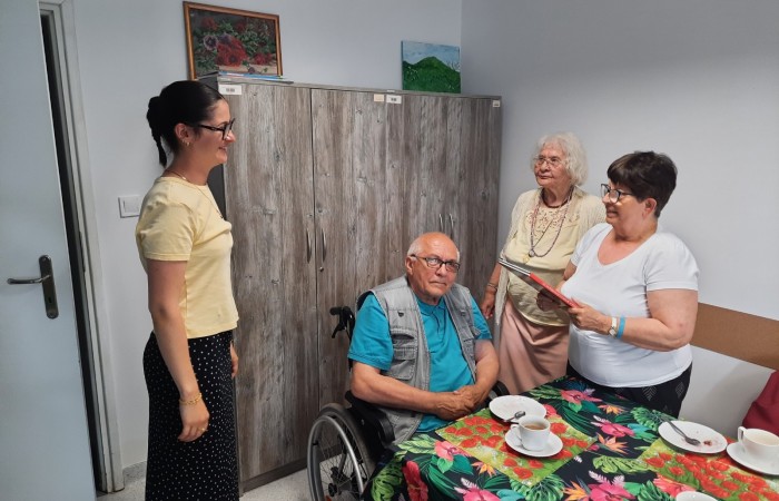 Zdjęcie przedstawia chwilę wręczenia Żuljet przez jedną z seniorek albumu pod tytułem Sto najpiękniejszych miejsc w Polsce.