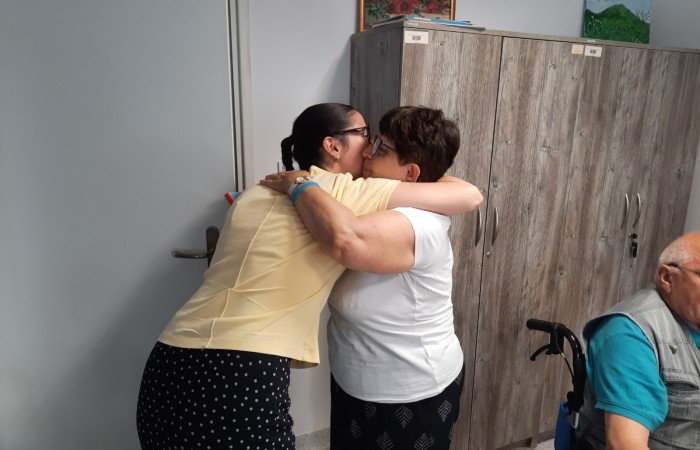 Chwila po wręczeniu albumu. Seniorka ściska się serdecznie z wolontariuszką.