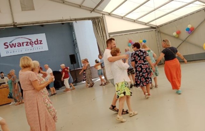 Zdjęcie przedstawia kolejną muzyczną aktywność wymyśloną przez wspaniałego prowadzącego. Tym razem uczestnicy tańczą w parach i reagują na taneczne polecenia.